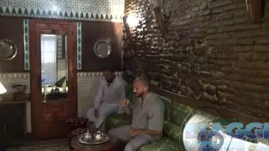 Un Marocain en djellaba élevé par une ourse dans un bar à chicha