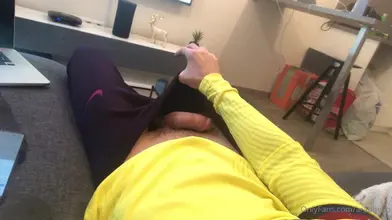 Allongé sur le canapé dans mon sweat jaune — la main dans mon jogging sombre