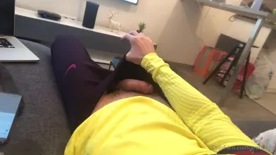 Allongé sur le canapé dans mon sweat jaune — la main dans mon jogging sombre