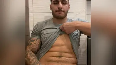 Je relève mon tee gris pour montrer mes abdos puis je sors ma bite