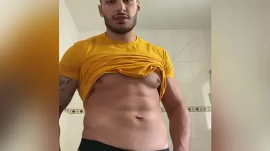 Je soulève mon t-shirt jaune pour montrer mes abdos et te faire envie