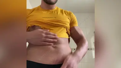 Je soulève mon t-shirt jaune pour montrer mes abdos et te faire envie