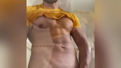 Je soulève mon t-shirt jaune pour montrer mes abdos et te faire envie