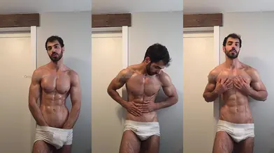 Faisal s'enduit d'huile en slip blanc contre la porte de la chambre